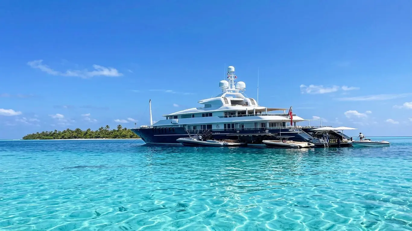 Superyacht anchored in clear Maldivian water beside a tropical island